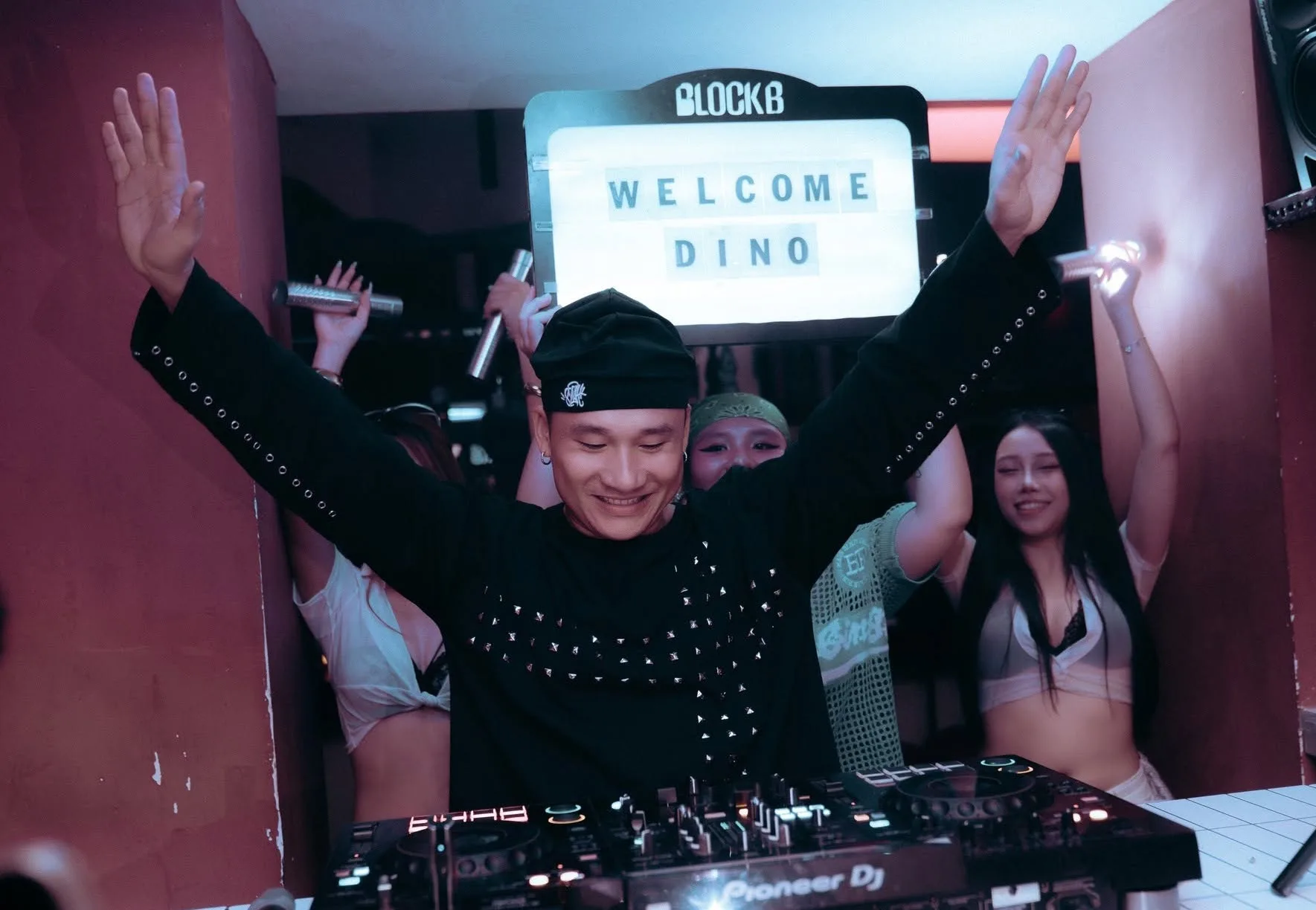 DJ giang tay sau bàn mixer trước biển chào BLOCKB tại Block B Hà Nội